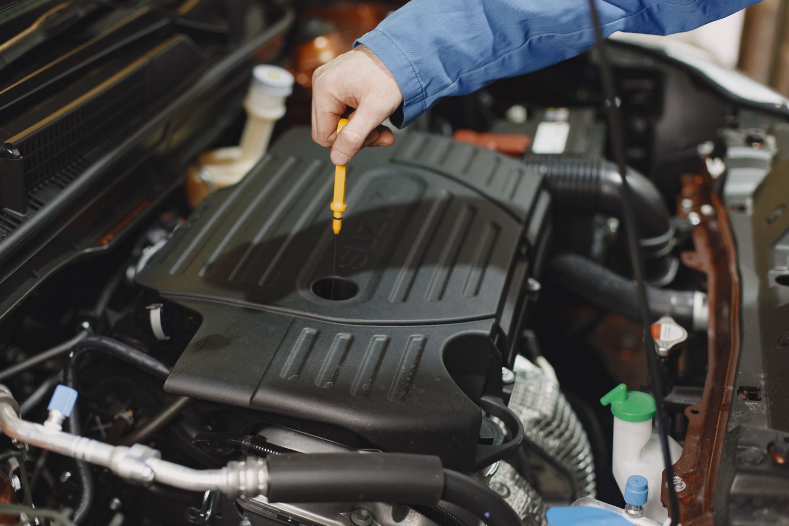 Yağ çubuğu ve motor içi seviyeyi kontrol eden teknisyen
