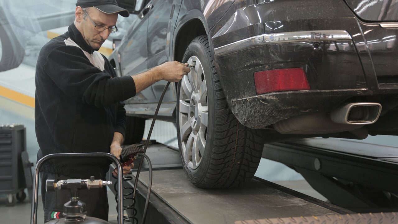 Teknisyenin lastiğin basıncını ölçmesi