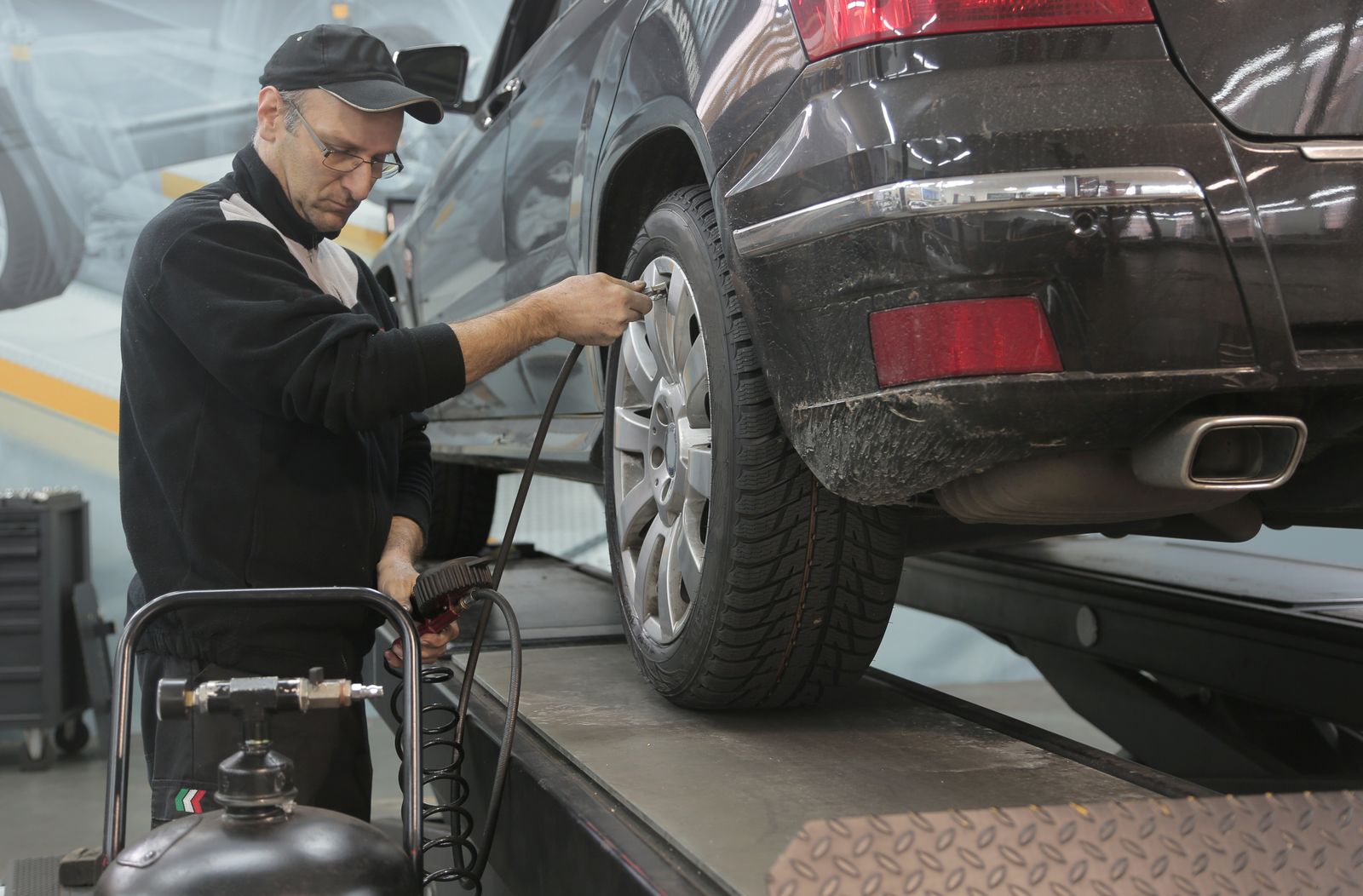 Teknisyenin lastiğin basıncını ölçmesi